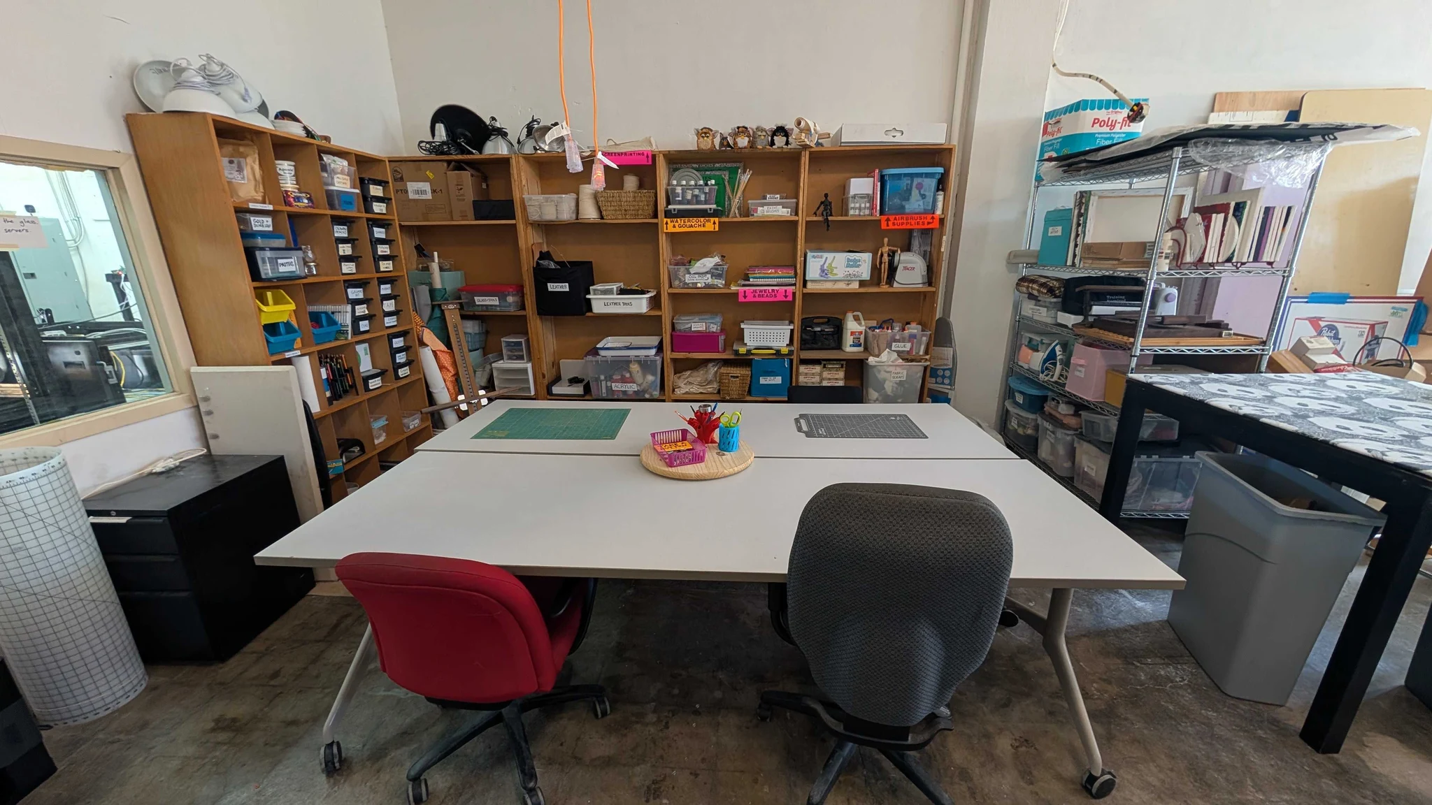 Craft Lab worktables with cutting mats, scissors, and shelves of labeled art and textile supplies